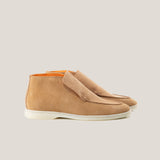 A pair of light beige suede ankle loafers with a white sole and visible stitching details.