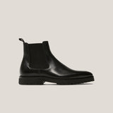 Black Chelsea boot on a light gray background